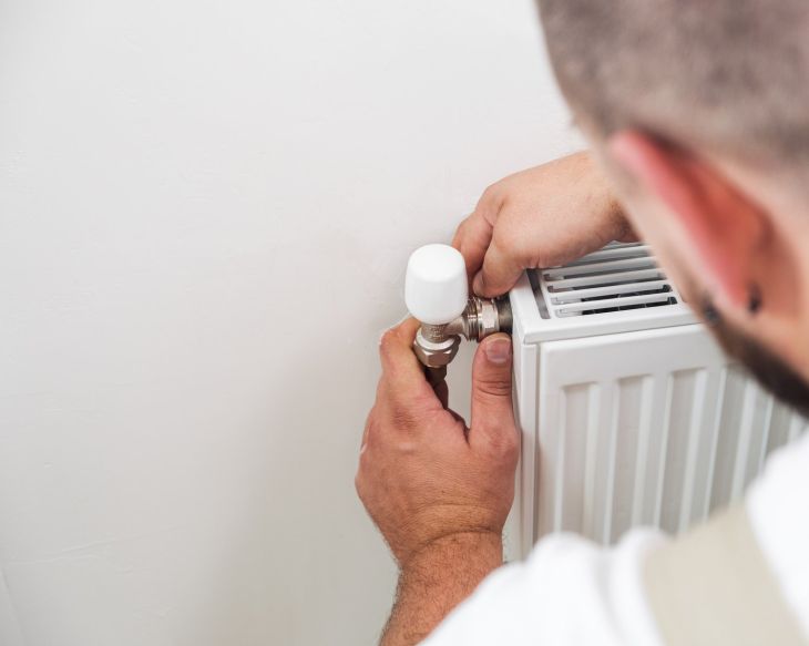 Instalator przy wymianie grzejnika